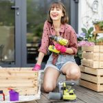 Housewife repairs wooden boxes on terrace