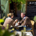 Un couple en train de partager un moment de complicité, comme une promenade dans un parc ou un repas à la maison.