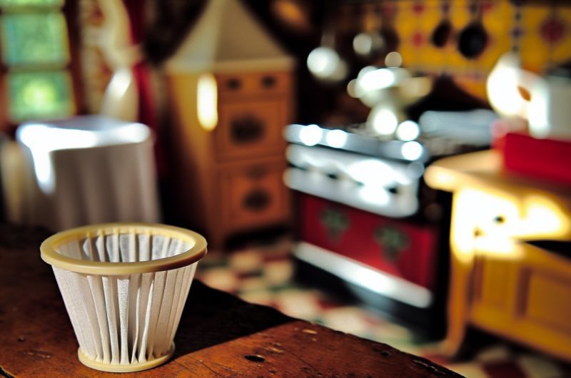 Des filtres à café en papier disposés sur une table, avec divers objets du quotidien pour suggérer des utilisations alternatives.