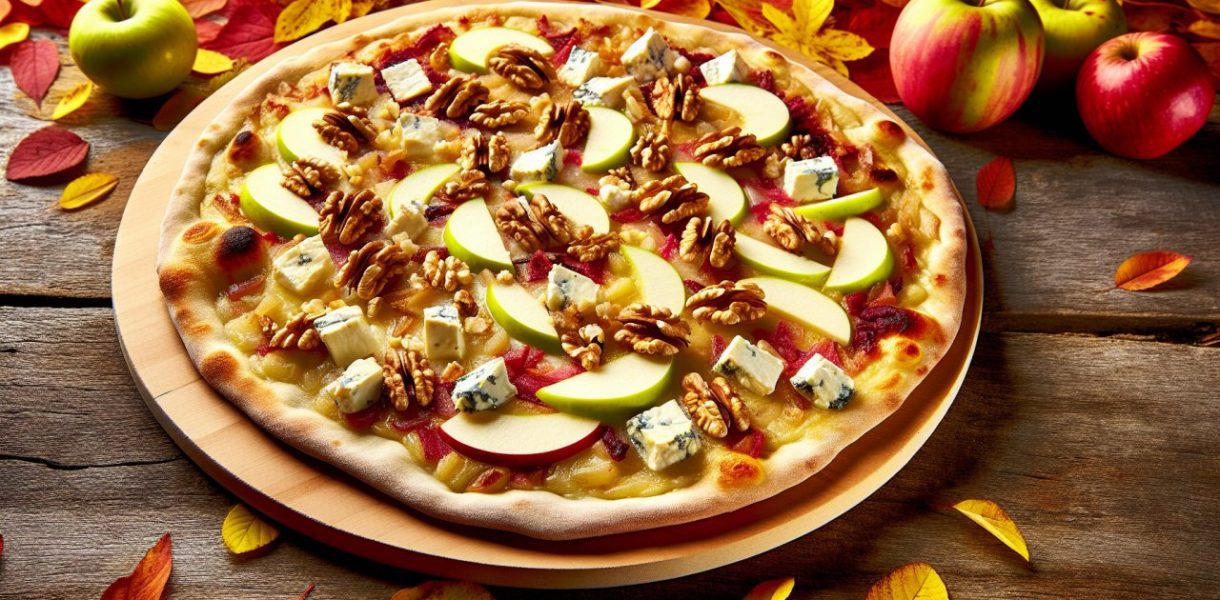Une pizza garnie de tranches de pommes, de morceaux de gorgonzola et de noix, posée sur une table rustique avec des feuilles d'automne en arrière-plan.